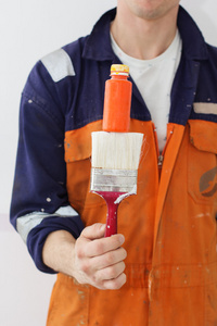 男子工人控股油漆刷和颜色管