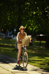 年轻漂亮的女人与自行车在公园。