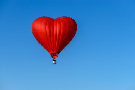 红热气球在蓝色的天空的一颗心的形状