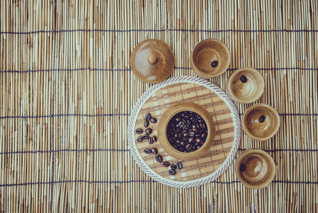 咖啡豆和咖啡杯子上竹木质背景设置。照片