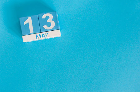 5 月 13 日。5 月 13 日木制彩色日历在蓝色背景上的图像。春日里，空的空间，为文本