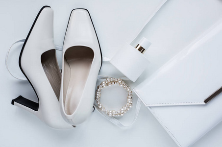白色的女性配件。香水和鞋子的手提包