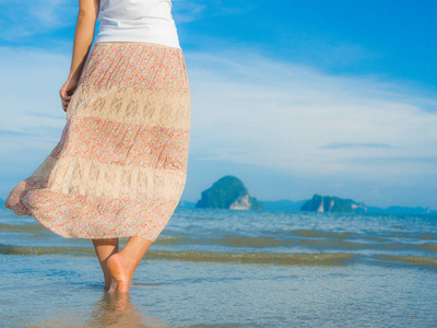 海滩旅行女人在沙滩上行走。女性的脚特写细节。加强概念