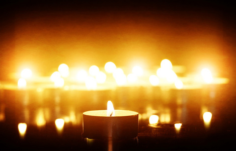 特写在黑暗中拿着蜡烛的手年轻人在黑暗中