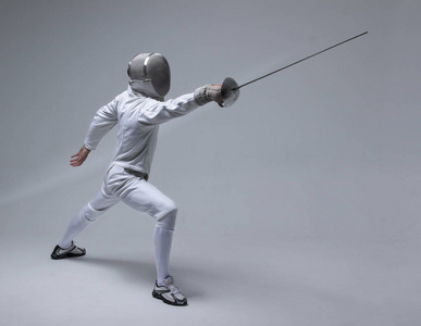 专业击剑击剑面具攻击在灰色的背景上剑战士活跃年轻男子击剑运动剪影