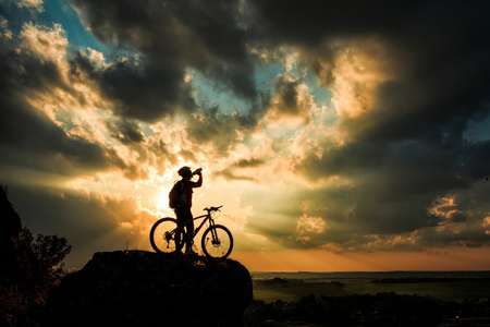骑自行车的人和自行车对星空背景下的剪影