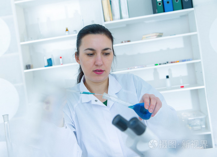 分析样品的年轻女科学家分析样品在 Laboratory.laboratory 助理