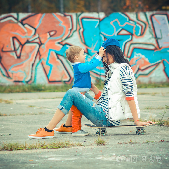 母亲和儿子踩着滑板
