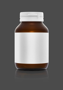 空白的棕色补充 prroduct 瓶与孤立在灰色的背景上的白色标签