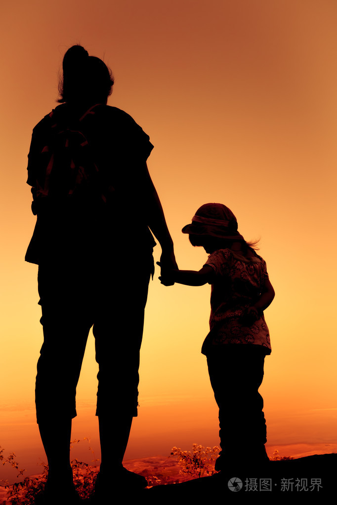 母亲和女儿在一起扣手剪影后面观