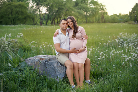 家庭爱的情侣，在森林公园的女人怀孕未来家长在的期待