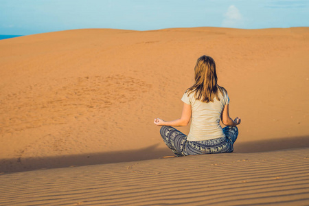 冥想在沙漠中的年轻女子