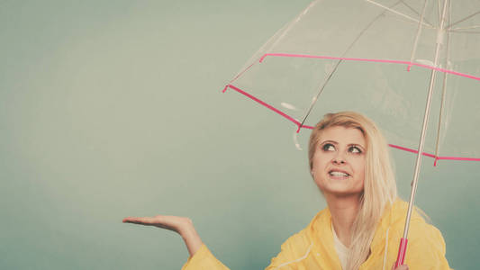 女人穿着雨衣打着伞检查天气