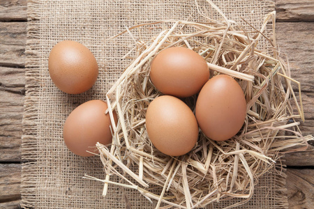 草窝蛋鸡蛋在干草窝在旧木照片