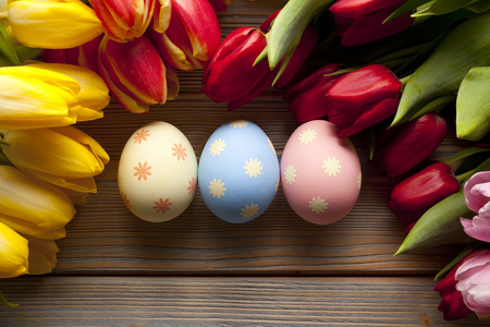 复活节彩蛋和艳丽的花朵，木质的背景