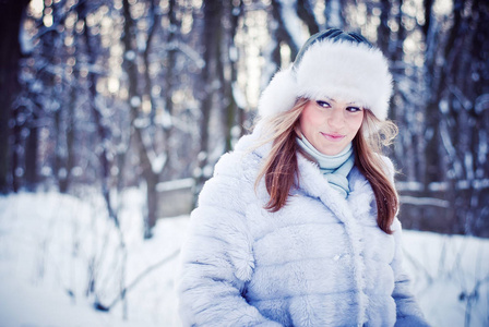 美丽的女孩在一个下雪的冬天公园