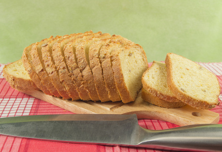 切片的小麦面包上切板特写。刀，红餐巾