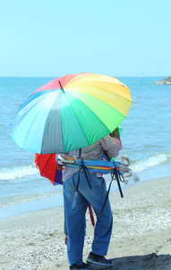 夏天海滩上五颜六色的雨伞的老小贩