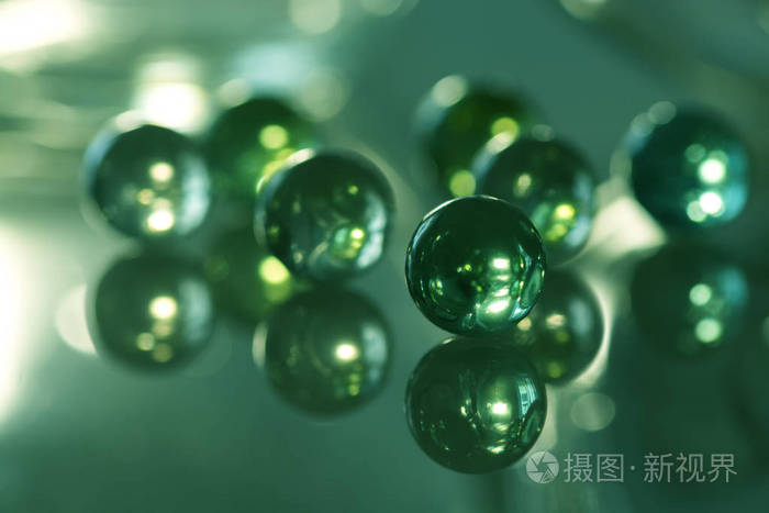 玻璃球用绿色反射玻璃桌上.七个玻璃球.选择性的焦点