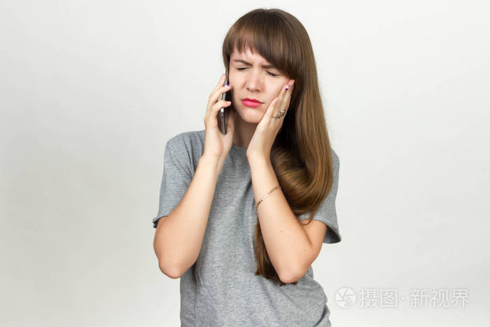 一位漂亮的女子 有牙痛站在灰色背景的画像 打电话叫医生照片 正版商用图片0dtkcw 摄图新视界