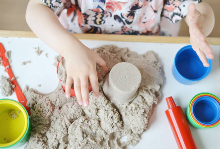 小女孩玩动力学沙子在早期的家庭教育
