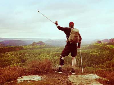 男子徒步旅行服装支持的腿支撑和反对 cruthes。天然的森林公园