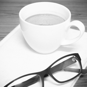 咖啡杯和戴着眼镜黑色和白色的笔记本颜色色调