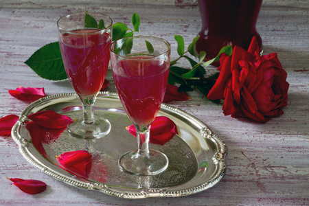 从玫瑰花瓣在木桌上的酒