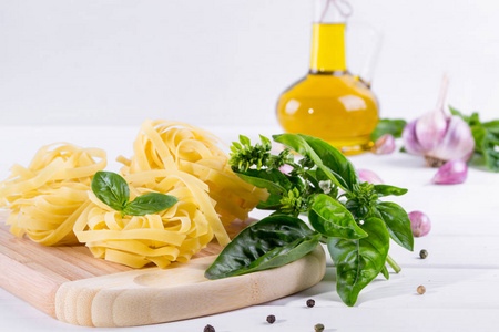 用大蒜 橄榄油和原始面食白色餐桌上的绿色紫苏