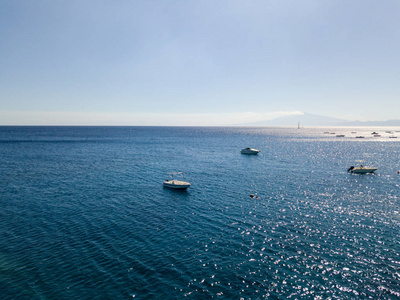 透明的海上漂浮的系泊船的鸟瞰图。暑假和潜水的放松。意大利的海岸 海滩和岩石。埃特纳火山在背景中