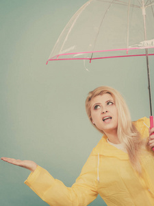 女人穿着雨衣打着伞检查天气图片