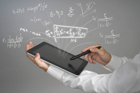 男人的科学家或学生拿着平板电脑和使用各种高中数学和科学公式