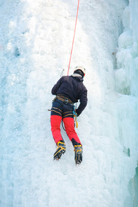 男子攀爬冰的瀑布