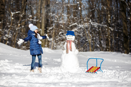小女孩玩堆雪人