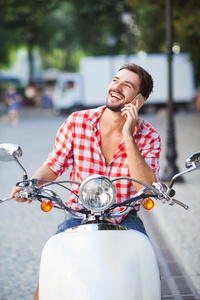 年轻男子骑摩托车与电话