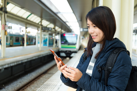 女人在火车平台上使用手机图片