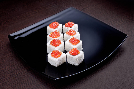 在黑版上的鱼子酱寿司 maki 设置。日本食品分离背景