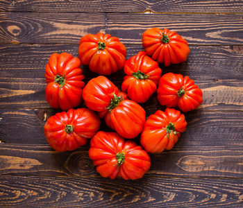 西红柿的心牛心西红柿,在仿古木的背景下,自由空间为特克斯照片