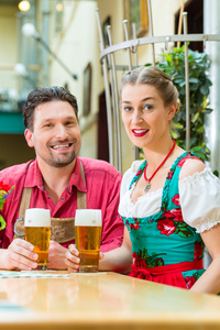年轻的夫妇在巴伐利亚在餐厅或酒吧