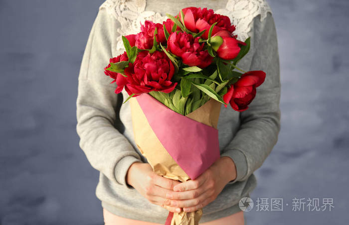 女人抱着艳丽的牡丹花束
