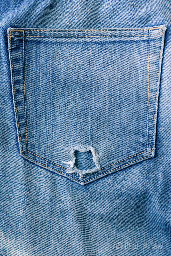 撕裂的蓝色牛仔布牛仔裤口袋里,老式的纹理照片-正版商用图片0dx2do