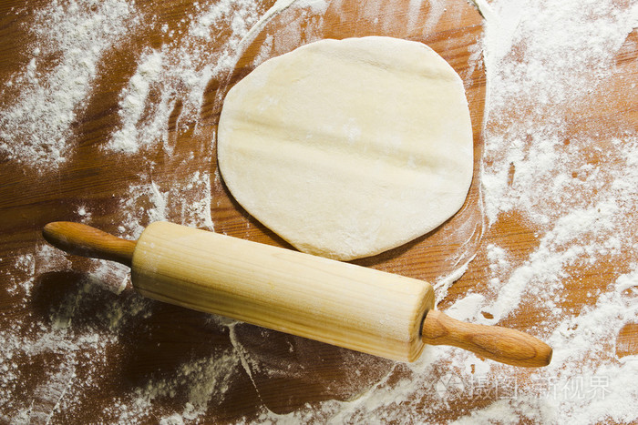 鸡蛋, 擀面杖和面团在厨房里木制的桌子上