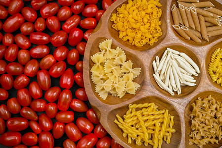 各种混合意大利面在木碗小红番茄特写