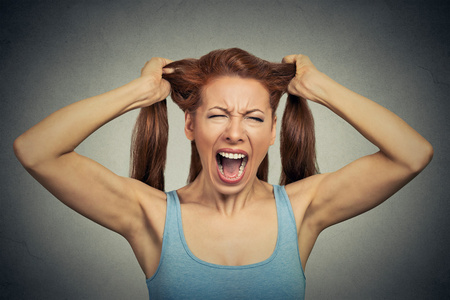 一个非常愤怒的女人的肖像,尖叫着照片