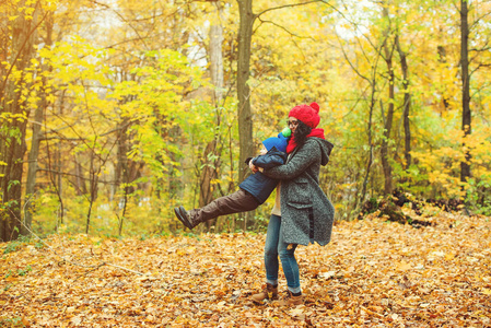 幸福的母亲和儿子散步 玩耍在一起在秋天公园的乐趣