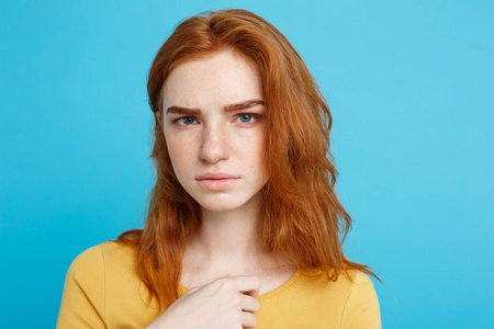 关闭了感觉紧张看着相机的肖像年轻美丽诱人 redhair 女孩。柔和的蓝色背景。复制空间