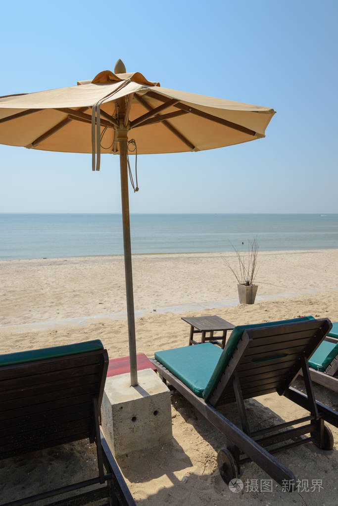日光浴浴床和遮阳伞,伞沙滩椅在海滩上.夏季度假概念