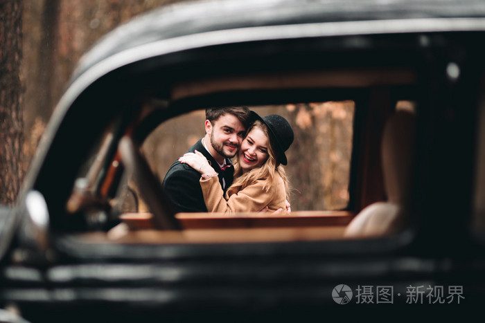 时尚爱婚礼情侣接吻和拥抱在一片松树林附近复古车