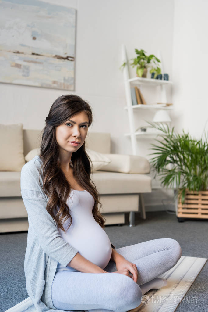 怀孕的女人坐在莲花的姿势