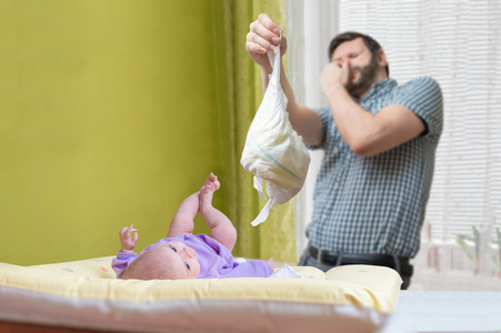 婴儿护理概念。父亲 od 爸爸换臭尿布